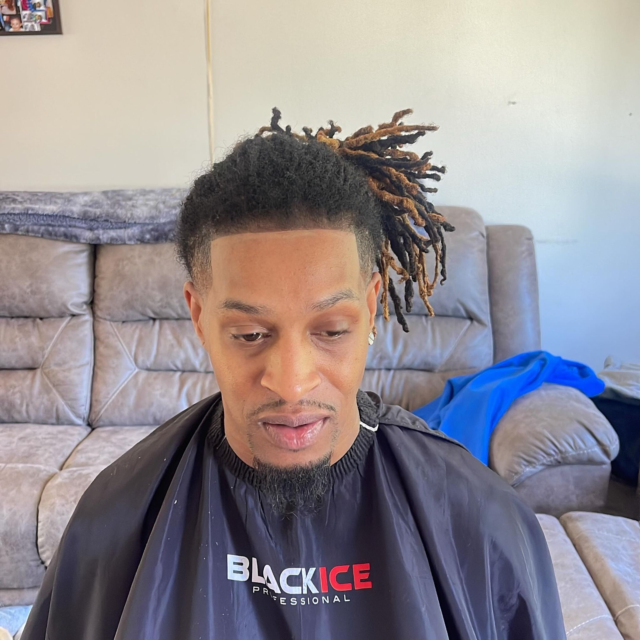 Front view of a crisp line-up and tapered temples with locs pulled up and back